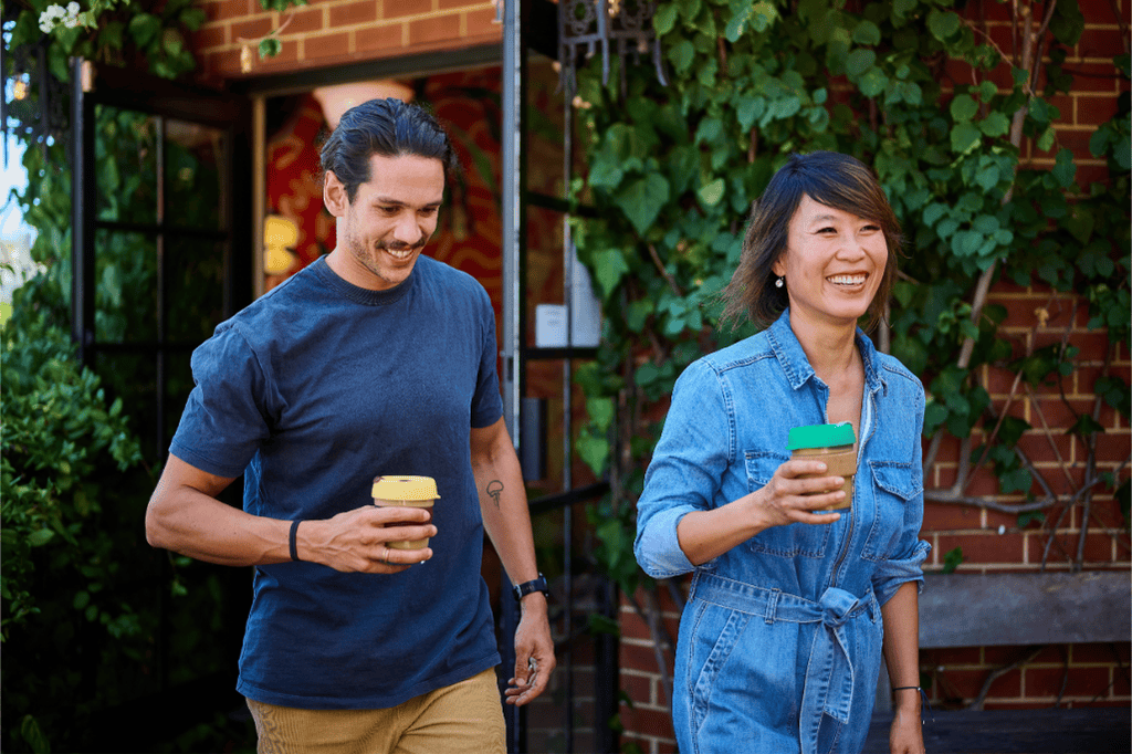 Close up man and a woman holding reusable takeaway cups