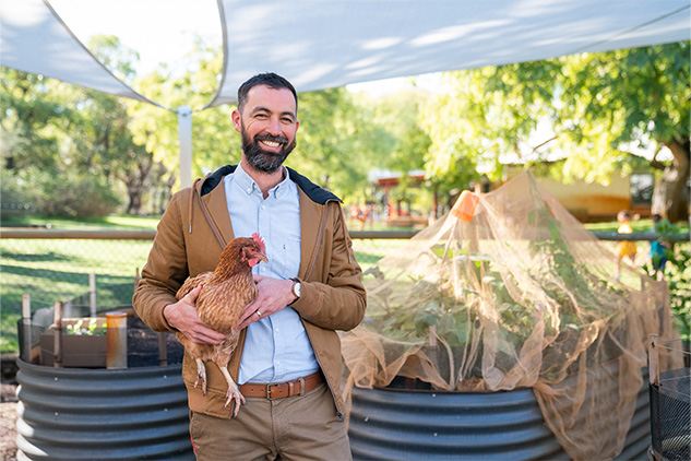 Tim Mangano sustainability leader and science teacher at Beeliar Primary School, holding a chicken